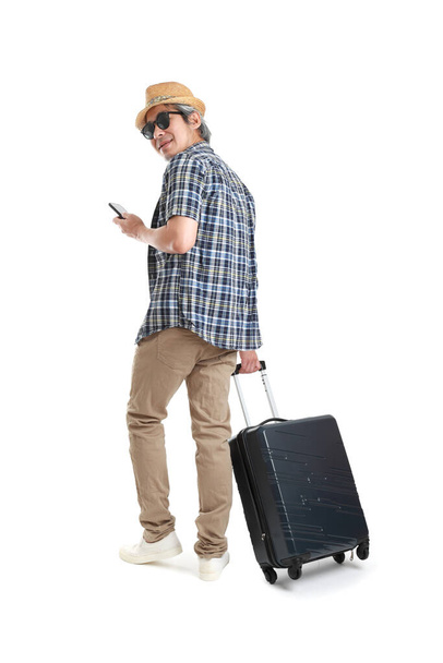 The senior Asian man standing with luggage on the white background. - Foto, afbeelding