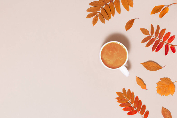 Autumn composition with cup of coffee and red autumn leaves on pink colored background. Cozy atmosphere and hot coffee with milk. Minimal flat lay, autumnal concept. Copy space - Fotoğraf, Görsel
