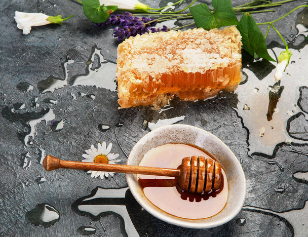 Honeycomb and honey in bowl on dark background. Organic food concept. Top view, flat lay, copy space - Zdjęcie, obraz