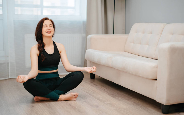 Young woman does yoga exercises indoors at home. - Fotó, kép