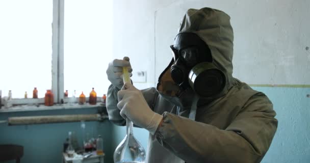 Wetenschapper arts in beschermende kleding en gasmasker in gevarenzone. Injecteren voor een patiënt - Video