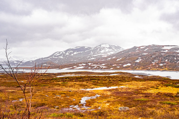 Amazing Vavatn lake panorama rough landscape view rocks boulders and mountains with snow during summer in Hemsedal Norway. - Foto, imagen