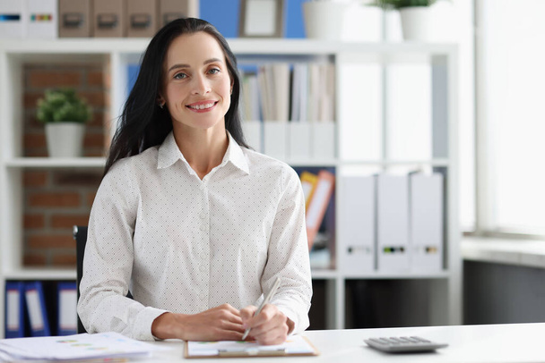 Hymyilevä naispuolinen yrityskonsultti virassa olevassa työpöydässä - Valokuva, kuva