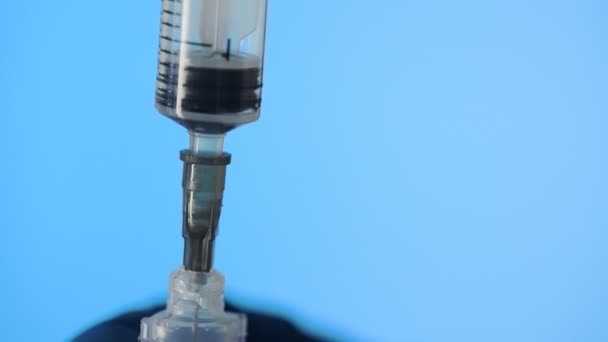 Detailní záběr rukou lékaře připravujících vakcínu pro injekci na modrém pozadí - Záběry, video