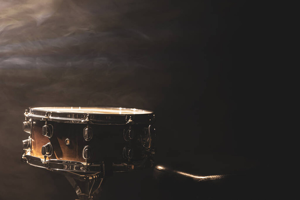 Tambor de caja sobre fondo negro, instrumento de percusión en la oscuridad con humo de escenario, espacio para copiar. - Foto, imagen