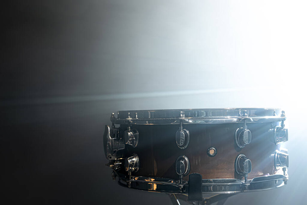 Snare τύμπανο, κρουστό όργανο στο φόντο ενός φωτεινού προβολέα σκηνής. - Φωτογραφία, εικόνα