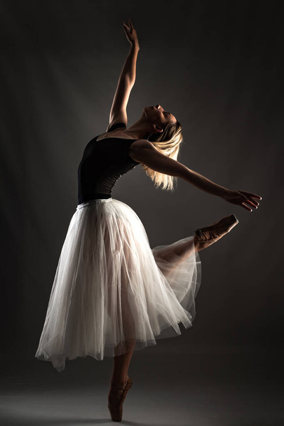 ballerina with a white dress and black top posing on gray background - Foto, Imagen