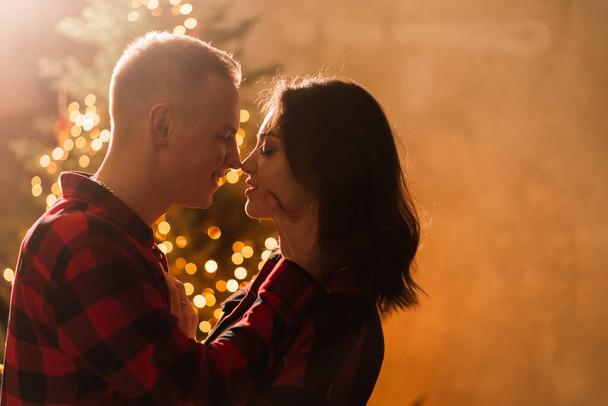 Мужчина удивляет женщину на Рождество, любящую и целующуюся пару - Фото, изображение