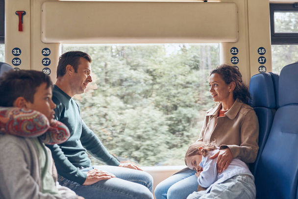 Family with two little kids enjoying train journey together - Zdjęcie, obraz
