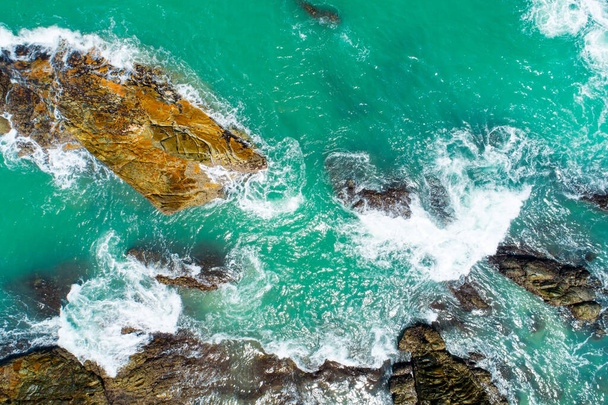 Uitzicht vanuit de lucht Top down Seashore wave crashen op de kust Prachtige turquoise zee oppervlak in zonnige dag Goed weer dag zomer achtergrond - Foto, afbeelding