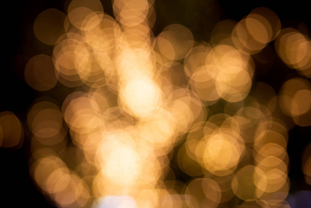 Gold or yellow bokeh texture background with glowing and illuminated, holiday and festive for celebration, New Year or Merry Christmas, no people, blur and defocused with graphic or effect. - Photo, Image