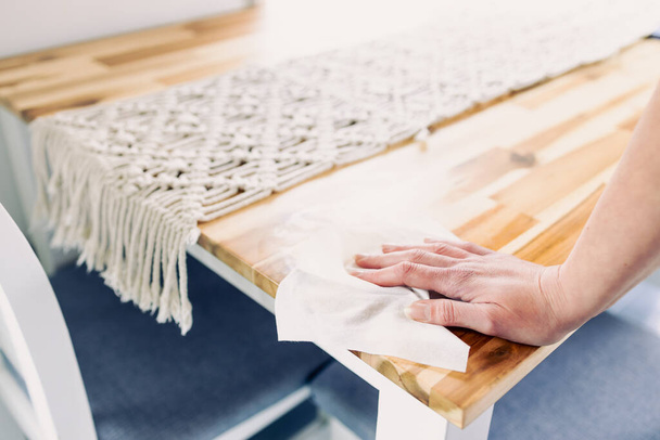 disinfecting surfaces from bacteria or viruses, hand cleaning dining table with disinfectant wet wipe cleanliness in your home or hospitality business - Φωτογραφία, εικόνα