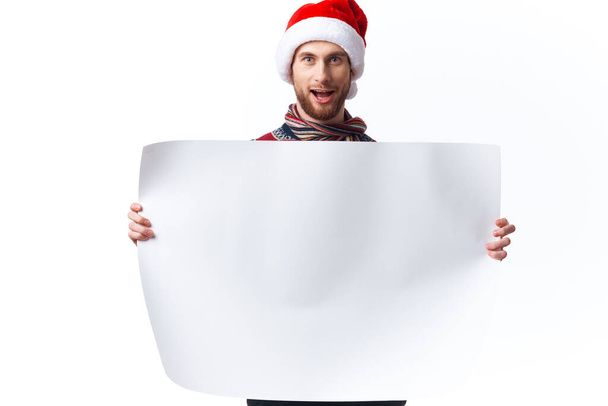 Homem alegre em um chapéu de Natal com cartaz branco mockup Natal estúdio de cópia-espaço - Foto, Imagem
