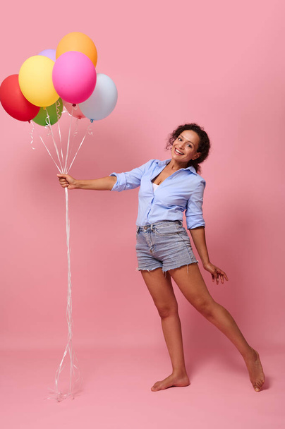 Full length body size portrait of nice-looking attractive lovely feminine cheerful wavy-haired beautiful mixed race woman holding air balls posing having fun isolated on bright pink color background - Фото, изображение