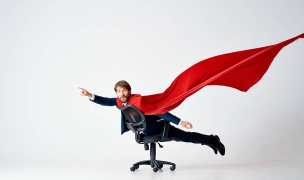 椅子のスーパーヒーローの赤いマントのスーツの男 - 写真・画像