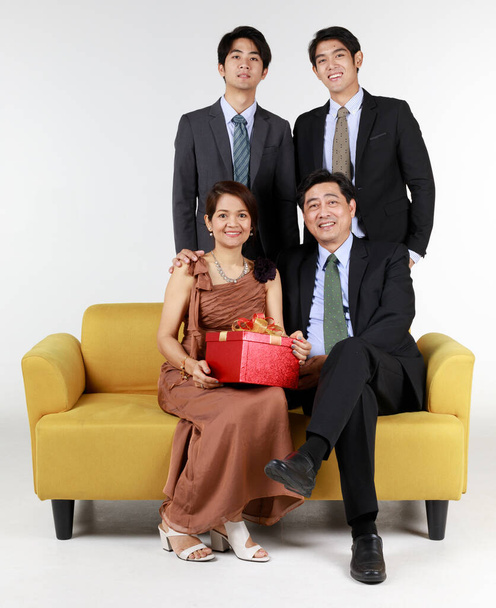 Studio ampua Aasian neljä jäsentä perhekuvia valkoisella taustalla ja tilalla lahjapakkauksessa onnellinen ja rakkaus tunteita. Mieleenpainuva hetki - Valokuva, kuva