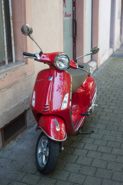 Colmar - France - 18 September 2021 - Front view of red vespa scooter parked in the street  - Photo, image