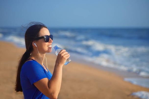 mujer bebe agua en la playa del mar
 - Foto, Imagen