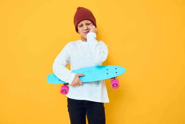 Grappig jongetje met rode rugzak blauw skateboard Childhood lifestyle concept - Foto, afbeelding