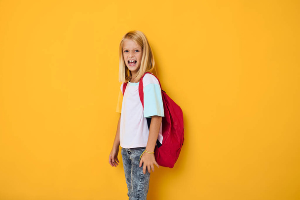 Улыбающаяся школьница блондинка школьный рюкзак представляя концепцию образования - Фото, изображение