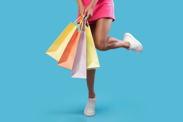 Mujer irreconocible sosteniendo bolsas de compras en el estudio - Foto, imagen