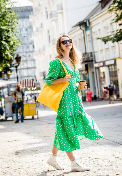 Mujer joven y hermosa con bolso ecológico de lino amarillo en el fondo de la ciudad. - Foto, imagen