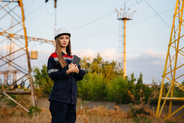 A young engineering worker inspects and controls the equipment of the power line. Energy - Foto, imagen