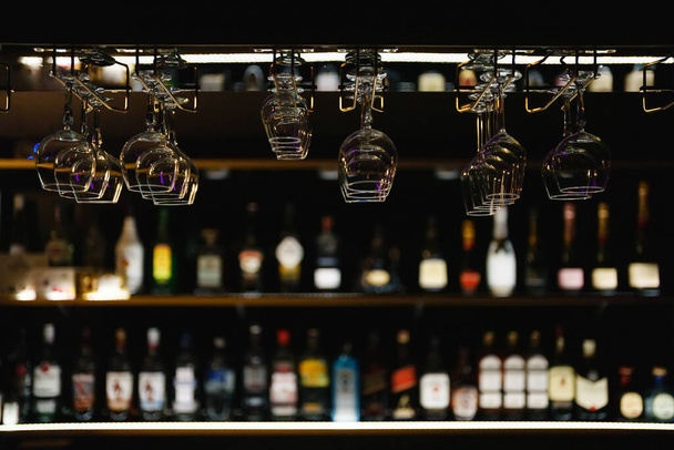 Glazen opgehangen boven de bar staan in de bar. - Foto, afbeelding