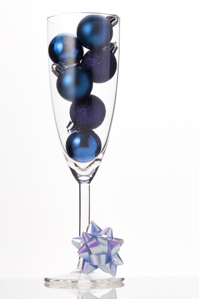 blauwe kerst ornament in een glas champagne - Foto, afbeelding