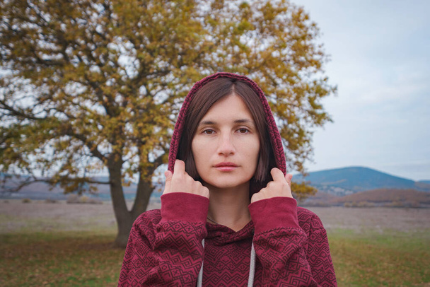 Portrait of a young woman in hoodie in the nature - Photo, Image
