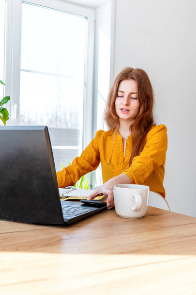 Young woman teaches English online on the Internet using a computer. Female freelancer is browsing in a laptop. Technology and people. Comfort zone in the house. Network business. - Photo, Image