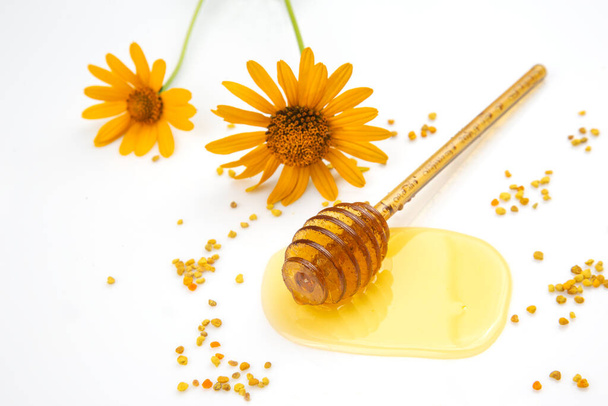 spoon with fresh honey and pollen spilled on a white background. organic vitamin food - Фото, зображення