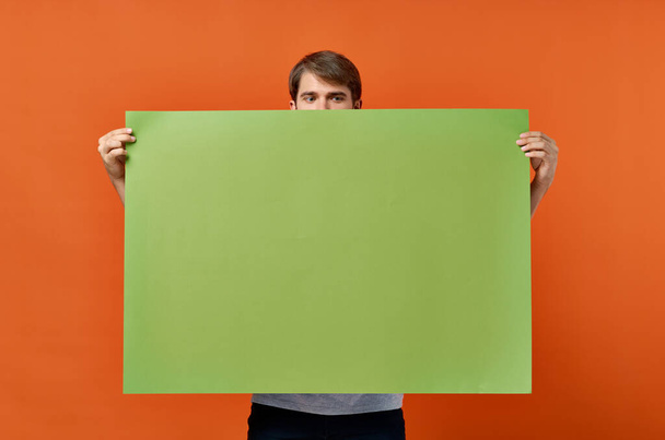 hombre emocional sosteniendo una pancarta verde estilo de vida de estudio de diseño - Foto, imagen