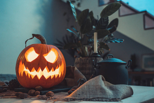 Scary halloween pumpkin. Dark background with colorful lights. Halloween theme. Scary postcard. Horror face. Card invitation. Lantern with burning candles, still life. Spooky, evil, celebration. - Zdjęcie, obraz