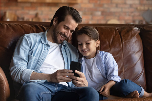 Happy father and little son having fun with smartphone - Foto, immagini