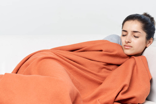 mujer se acuesta con los ojos cerrados cubiertos con un tratamiento frío manta - Foto, imagen
