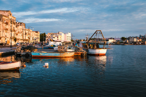 Taranto, Italy - August 2021: Boats moored in the port of Taranto Vecchia at dawn - Фото, изображение