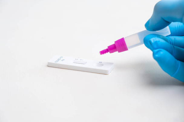 Kapka činidla do COVID-19 Test na protilátky laboratorním pracovníkem v gumových rukavicích - Fotografie, Obrázek