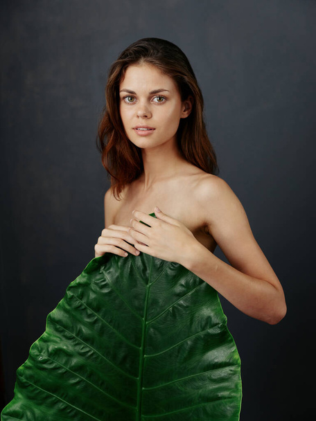 mujer atractiva cubre cuerpo desnudo con encanto de hoja verde - Foto, Imagen