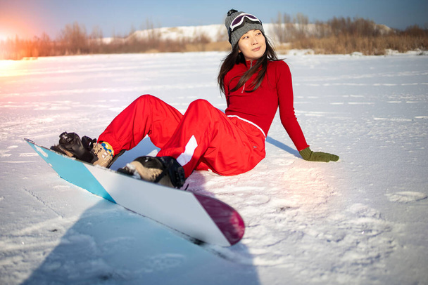 moda inverno foto de bela mulher asiática em roupas esportivas posando com snowboard na floresta - Foto, Imagem