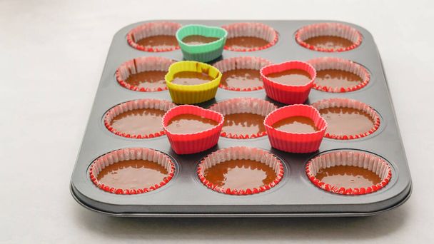 Schokolade Cupcakes Rezept. Cupcake-Pfanne mit Papierauskleidungen und Silikonformen gefüllt mit Schokoladenkuchenteig - Foto, Bild