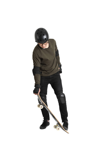 The Asian man with protective gear and skateboard standing on the white background. - Photo, image