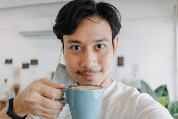 Close up of Asian man selfie himself drinks hot coffee. - Photo, Image
