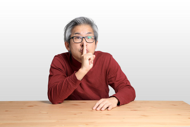 The Senior Asian man sitting at the desk on the white background. - Photo, Image