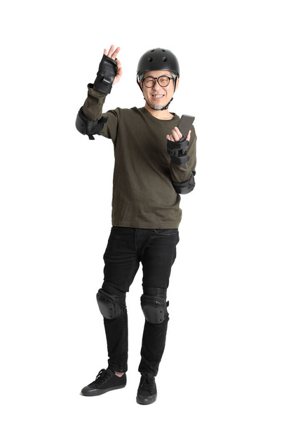 The Asian man with protective gear standing on the white background. - Foto, afbeelding