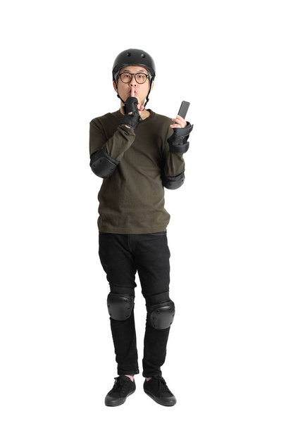 The Asian man with protective gear standing on the white background. - Foto, imagen