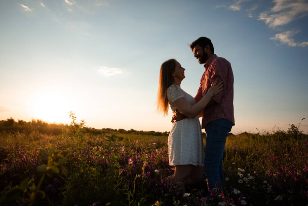 Embracing couple in rays of setting sun - Photo, image