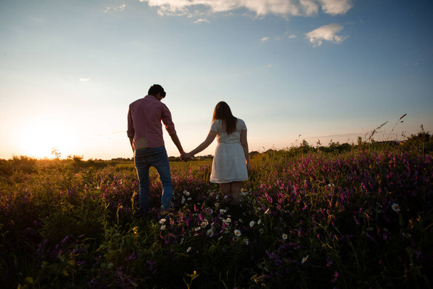 Lovely couple walking in the summer field - Φωτογραφία, εικόνα