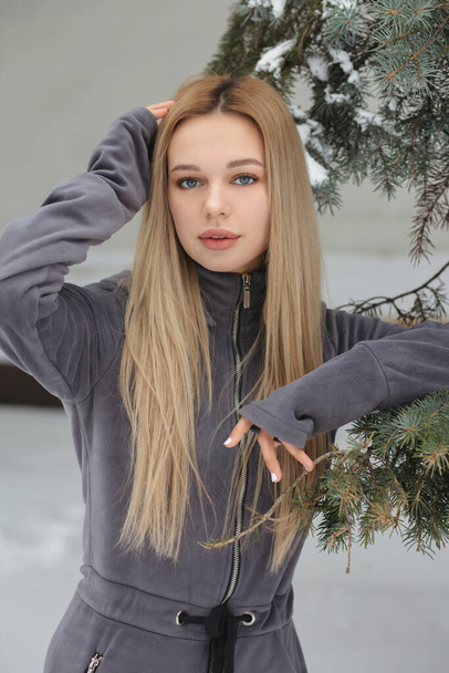 Pretty woman with long hair posing in the forest in winter - Photo, Image