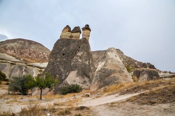 Piękny krajobraz Kapadocji. Unikalne formacje geologiczne z kamiennych domów skalnych i jaskiń Turystyka i podróże. - Zdjęcie, obraz